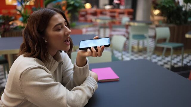 Artificial intelligence receives playful gratitude as woman smiles and flirts with voice assistant appreciating helpful answers and friendly support in everyday digital communication