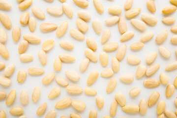 Almond nuts on light gray table background. Closeup. Food pattern. Top down view.