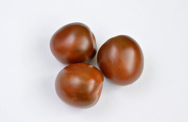 Three Ripe Kumato Tomatoes on a White Background cut out