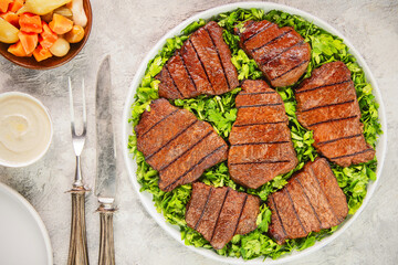 Middle Eastern grilled beef fillet placed on a bed of fresh parsley. Served with tahini sauce, pickles and pita bread.