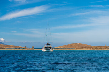 Sailboat cruising near Delos island with Mykonos coastline Greece © Juan