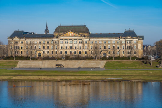 View of the Saxon State Chancellery reflected in the Elbe River's waters, with its architectural details glowing under the sunlight, Dresden, Saxony, Germany.