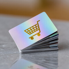 Iridescent gift card stack holographic card shopping cart icon gold symbol retail payment metallic surface pastel glow modern design glossy finish minimal style. Clean background and soft light