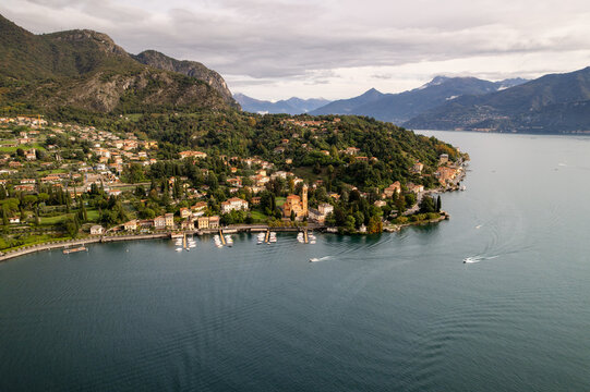 Aerial view of Tremezzo, where the town's terracotta roofs meet the deep blue waters of the lake, nestled beneath the watchful gaze of the rugged mountains, Tremezzo, Lombardy, Italy.