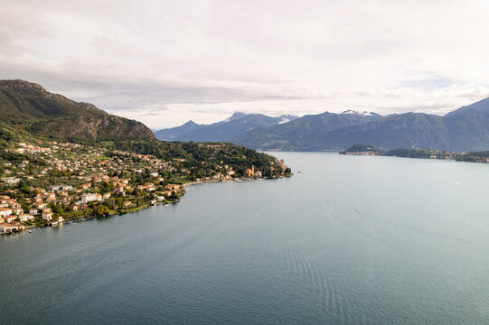 Aerial view of the tranquil lake waters reflecting the sky as they meet the verdant hills and charming settlements, Azzano, Lombardy, Italy.
