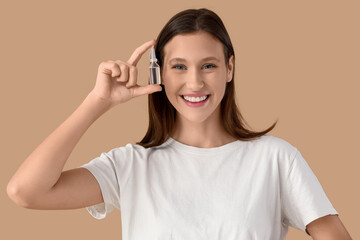 Young woman with eye drops on beige background