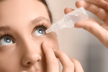 Young woman using eye drops in clinic, closeup
