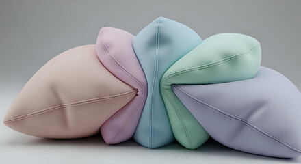 A row of soft, pastelcolored decorative pillows arranged in a fan shape against a light gray background