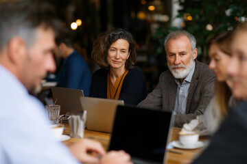 Fototapeta premium An engaging business meeting taking place in a cozy cafe, showcasing professionals exchanging ideas, fostering collaboration and innovation over coffee.