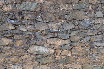 Fototapeta premium Photograph showcasing rugged limestone and granite wall with moss and shadow play for artistic projects