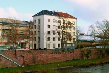 Fototapeta premium Peaceful waterside residence with scenery, Quiet dwelling by river featuring trees and calm reflections