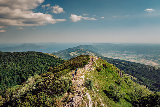 Aerial view of the rugged, verdant peaks of Mala Ucka, embraced by a hazy sky, reveal hidden trails and panoramic vistas, Mala Ucka, Primorje-Gorski Kotar County, Croatia.