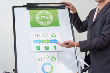 Businessperson presenting ESG environment social governance strategy and sustainable development goals on a whiteboard in a meeting