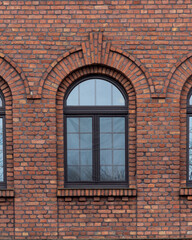 Historical brick wall with windows showcasing architectural design in an urban setting