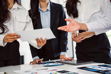 Business team collaborating, analyzing financial data, and discussing strategy in an office meeting setting