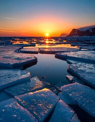 Atemberaubender  Sonnenuntergang im Hintergrund, im Vordergrund zerkl&uuml;ftete Eisschollen auf dem Meer.