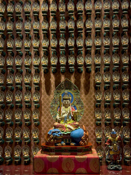 View of golden statues adorn a wall behind a serene Buddha, creating a spiritual tapestry of devotion and artistry, Kuala Lumpur, Federal Territory of Kuala Lumpur, Malaysia.