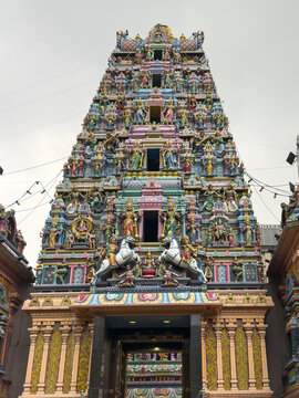 View of the vibrant Sri Kandaswamy Kovil temple facade with intricate carvings and sculptures under a cloudy sky, Kuala Lumpur, Federal Territory of Kuala Lumpur, Malaysia.
