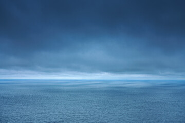 A panoramic aerial view of the Pacific Ocean with low-flying dense clouds obscuring the sky, Muroran, Hokkaido, Japan