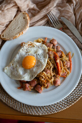 Homemade recipe for white sausage with fried egg on a dining table