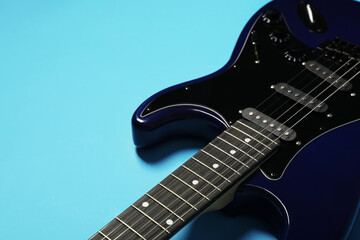 Obraz premium Modern electric guitar on blue background, closeup
