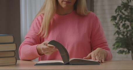 Naklejka premium Woman Reading Book at Wooden Table Indoors