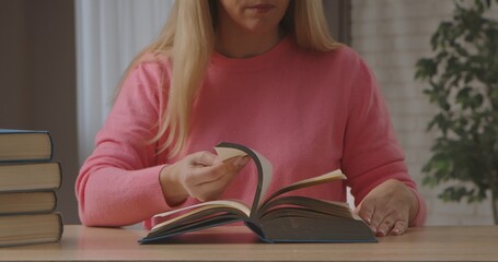 Naklejka premium Woman Reading Book at Wooden Table Indoors