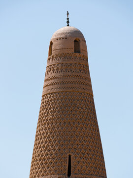 View of the Emin Minaret's textured mud-brick tower rises against a clear sky, a testament to ancient architecture, Turpan, Xinjiang, China.