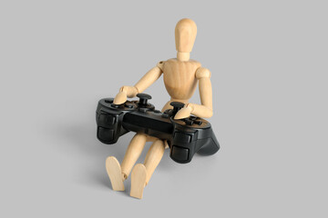 Wooden mannequin with game pad on light background