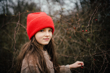 Naklejka premium Preteen girl on walk nature wearing red hat.