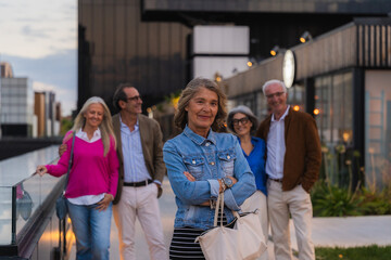 Group of smiling mature adult friends enjoying time together in a modern city setting