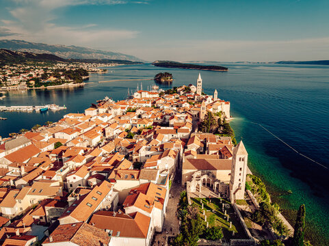 Aerial view of terracotta rooftops cascading towards the turquoise Adriatic, ancient spires piercing the skyline of Rab, a jewel on the Croatian coast., Rab, Primorje-Gorski Kotar County, Croatia.