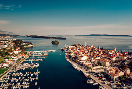 Aerial view of the old town's terracotta rooftops cascading towards the Adriatic, a tapestry woven between the sea and sky, Rab, Primorje-Gorski Kotar County, Croatia.