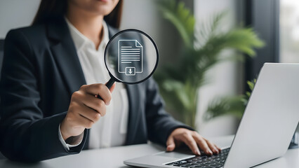 Businesswoman analyzing data on laptop with magnifying glass