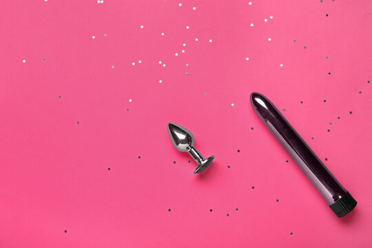 Vibrator and anal plug from sex shop on pink background