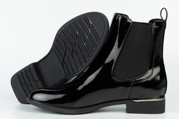 Stylish black boots with a smooth finish displayed on a white background