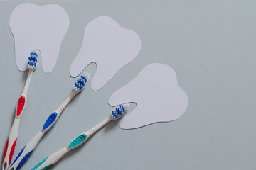 Dentist day. Top view of a toothbrush next to teeth on a light blue background.
