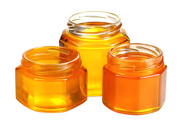 Three glass jars filled with golden honey isolated on white background