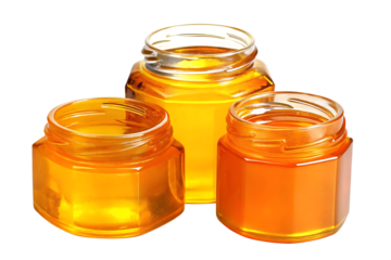 Three glass jars filled with golden honey isolated on white background