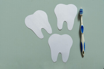 Top view of teeth next to a toothbrush, light blue background