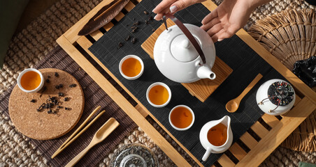 Woman with set of tea ceremony in room, top view