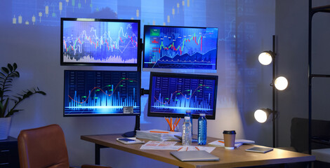 Interior of trader's office with workplace and glowing lamps at night