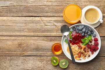 Healthy breakfast. Oatmeal with nuts, berries, yoghurt, coffee and orange juice on wooden table, flat lay. Space for text