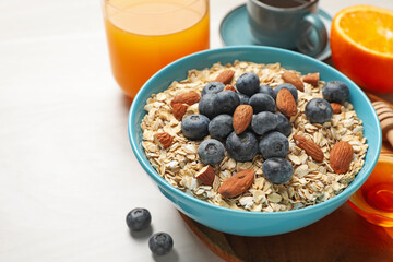 Dry oat flakes, nuts and blueberries on grey table for breakfast, closeup. Space for text