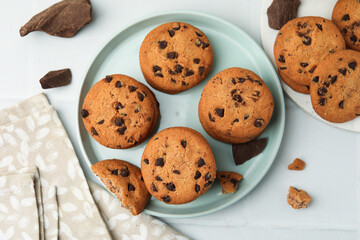 Delicious chocolate chip cookies on light table, flat lay