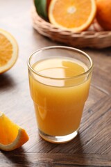 Fresh orange juice and fruits on wooden table, closeup