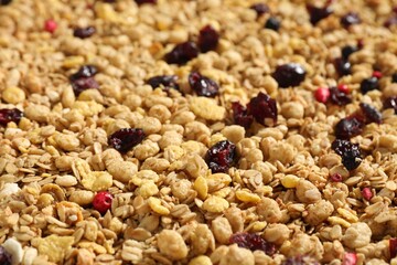 Tasty granola with dried fruits as background, closeup