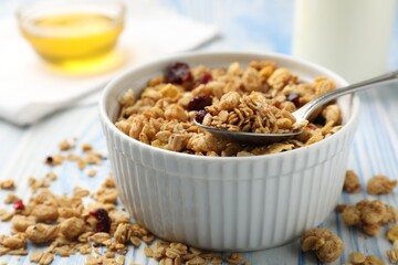 Tasty granola with dried fruits in light blue wooden table, closeup