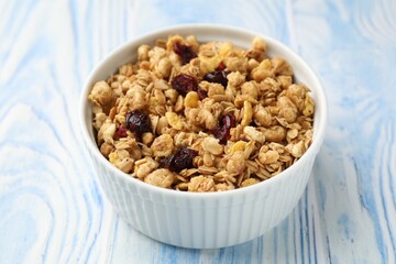 Tasty granola with dried fruits in light blue wooden table, closeup
