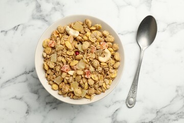 Tasty granola with dried fruits and nuts in bowl on white marble table, top view
